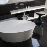 Luxuriöses Badezimmer, dunkles Design, moderne Badewanne, mit Stuhl und Regal.