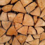 Geschnittenes und gestapeltes Kaminholz in einem offenen Holzlager zur optimalen Belueftung und Trocknung der Holzscheite