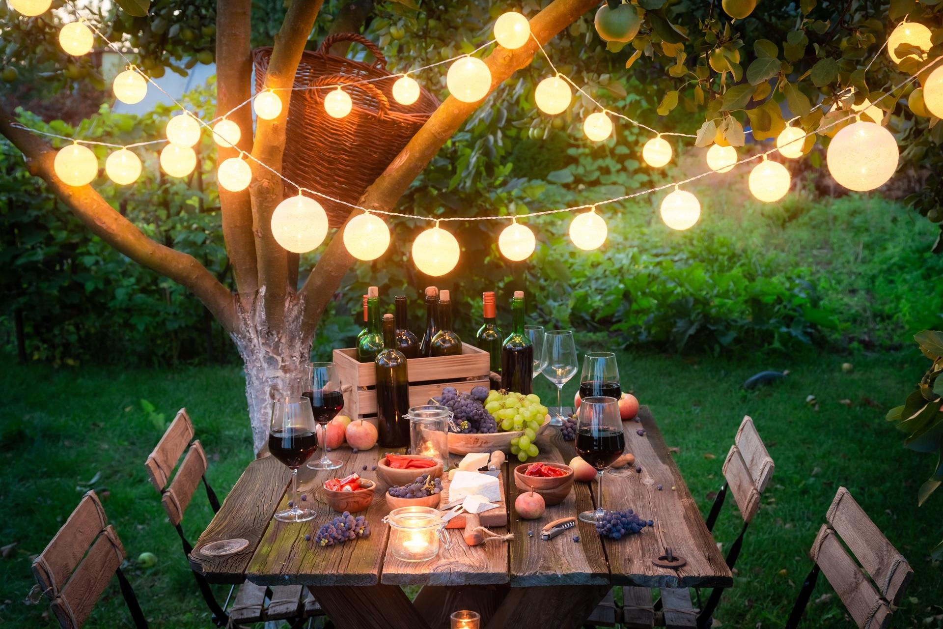 Beleuchteter Abendtisch mit Wein und Obst | Gartenküche

